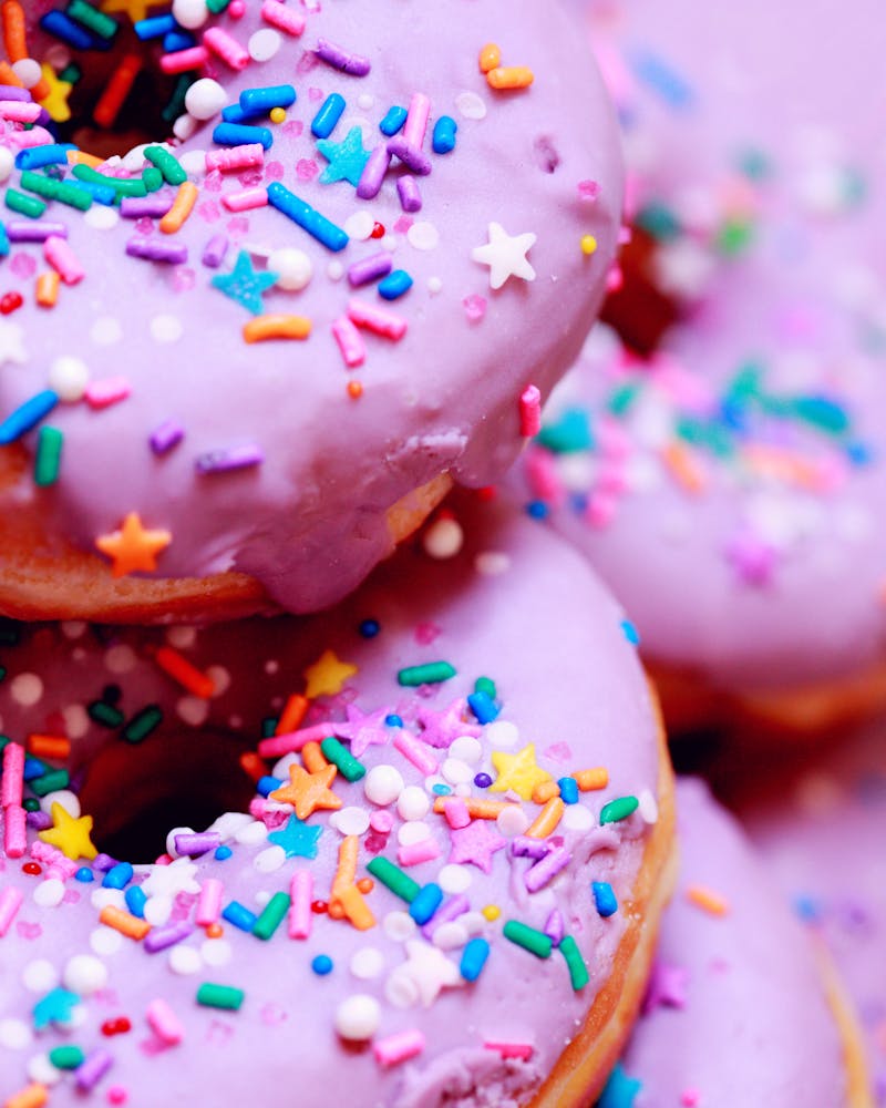 Pink glazed donuts with colorful sprinkles